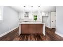 Bright kitchen featuring a stylish island, modern lighting, stainless vent hood, and sleek cabinets at 3978 Oglesby Rd, Powder Springs, GA 30127