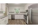 Bright kitchen features stainless appliances, granite counters, subway tile backsplash, and wood-look floors at 4248 Wellington Hills Ln, Snellville, GA 30039