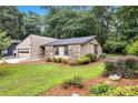 View of the home's exterior, enhanced by a landscaped yard with mature trees and native plants at 2786 Olde Gate Ct, Snellville, GA 30078