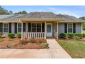 Inviting front porch with lovely landscaping and a walkway leading to the front door at 4841 Partee Trl, Social Circle, GA 30025