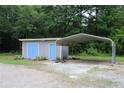 Outbuilding with a metal carport, side-by-side doors, and gravel area at 4841 Partee Trl, Social Circle, GA 30025