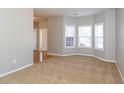 The living room features a large bay window and plush carpet at 122 Melrose Creek Dr, Stockbridge, GA 30281