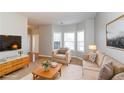 The living room is virtually staged with modern furniture, a TV, and a view of the bay windows at 122 Melrose Creek Dr, Stockbridge, GA 30281