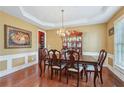 Formal dining room with hardwood floors, wainscoting, a chandelier, and a large dining table with seating at 251 Sumac Trl, Woodstock, GA 30188