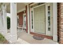 Inviting front porch with white columns, a rocking chair, and a decorative rug at the front door at 251 Sumac Trl, Woodstock, GA 30188