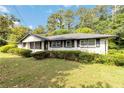 Inviting one-story brick home with well-maintained landscaping, dark shutters, and a cozy, classic design at 6873 Church St, Riverdale, GA 30274