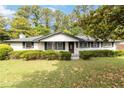 Beautiful one-story brick home featuring a manicured lawn, mature trees, and classic architectural details at 6873 Church St, Riverdale, GA 30274