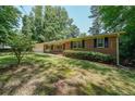 Traditional brick home with green lawn and mature trees at 213 Linda Dr, Tucker, GA 30084