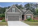 Charming Craftsman-style home with a well-maintained lawn, gray siding, brick accents, and an attached two-car garage at 2256 Long Bow Chase Nw, Kennesaw, GA 30144