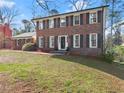 Traditional two-story brick home featuring black shutters, a tidy lawn, and classic design at 4076 Shady Nw Cir, Lilburn, GA 30047