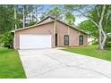 View of home featuring an attached garage and a well-manicured lawn at 8455 Cedar Creek Rdg, Riverdale, GA 30274