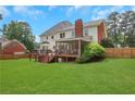 Expansive backyard featuring a screened porch, wooden deck, and lush green lawn, perfect for outdoor living at 2535 Winthrope Way, Lawrenceville, GA 30044
