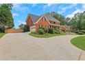 Spacious driveway leading to a well-maintained brick home with lush landscaping, basketball court, and two-car garage at 2535 Winthrope Way, Lawrenceville, GA 30044