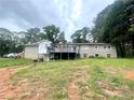 The back exterior of home shows a brick finish, as well as a deck with a partially wooded lot at 3750 Dial Mill Ne Rd, Conyers, GA 30013