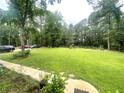 Spacious backyard with mature trees, wooden fence, and well-maintained lawn at 3750 Dial Mill Ne Rd, Conyers, GA 30013