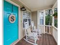 Cozy front porch with rocking chairs, a blue door with décor, and wood flooring at 5 White Pines Dr, Dallas, GA 30157