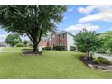 Well-maintained brick home with a lush lawn and mature trees in a suburban setting at 10735 Pinewalk Forest Cir, Alpharetta, GA 30022