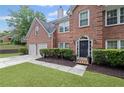 Charming brick home with a two-car garage, landscaped shrubs, and a welcoming front entrance at 10735 Pinewalk Forest Cir, Alpharetta, GA 30022