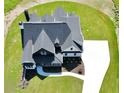 Aerial view of a two-story home with an intricate roofline, white driveway, and lush landscaping at 152 Palisade Dr, Rydal, GA 30171