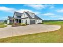 Side view of a modern farmhouse with a long driveway leading to an attached gray two-car garage at 152 Palisade Dr, Rydal, GA 30171