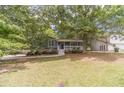 Charming home featuring a welcoming front porch, lush landscaping, and inviting curb appeal at 3404 Broxton Mill Way, Snellville, GA 30039