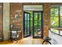 Balcony entrance next to exposed brick wall features a work station and overlooks lush greenery at 3235 Roswell Ne Rd # 505, Atlanta, GA 30305