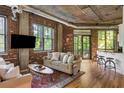 Bright living area featuring exposed brick, hardwood floors, and access to the outdoor balcony at 3235 Roswell Ne Rd # 505, Atlanta, GA 30305