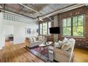 Spacious living room with modern decor, exposed pipes, and large windows for ample lighting at 3235 Roswell Ne Rd # 505, Atlanta, GA 30305