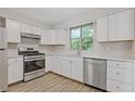Modern kitchen features stainless steel appliances, bright white cabinetry, and hardwood floors at 2426 Corner Shoals Dr, Decatur, GA 30034