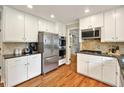 Modern kitchen featuring white cabinets, stainless steel appliances, and hardwood floors at 281 Lakeshore Ne Dr, Marietta, GA 30067