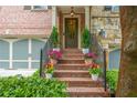Inviting front porch with brick steps, black iron railings, and potted plants, leading to the front door at 2025 Eagle Rdg, Roswell, GA 30076