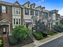 Townhome exterior featuring brick, shutters, manicured greenery, and well-maintained sidewalks at 3386 Vintage Se Cir # 8, Smyrna, GA 30080