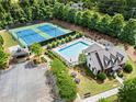 Aerial view showcases the community pool, tennis courts, and clubhouse surrounded by lush greenery at 4115 Williams Point Dr, Cumming, GA 30028