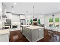 Modern kitchen with stainless steel appliances, granite countertops, a spacious island, and hardwood floors at 4115 Williams Point Dr, Cumming, GA 30028