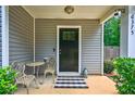 Inviting front porch featuring a small table and chairs, and a decorative black and white rug at 6375 Eidson Dr, Cumming, GA 30041