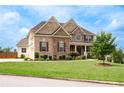 Charming two-story home with a brick facade, lush landscaping, and attached garage at 6585 Canyon Cv, Cumming, GA 30028