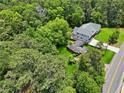 Aerial view of home with large lawn, backing to woods, and near a two-lane road at 905 John Ward Rd, Marietta, GA 30064