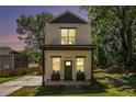 Stylish two-story home featuring a cozy front porch and a green lawn at 1473 Lansing Se St, Atlanta, GA 30315