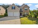 Two-story home with stone accents, a two-car garage, and a well-maintained lawn at 211 Millstone Dr, Hampton, GA 30228