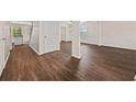 Open-concept living space featuring hardwood floors, white trim, and modern lighting at 211 Millstone Dr, Hampton, GA 30228
