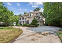 Two-story brick home with private drive and mature landscaping, enhanced by a well-manicured lawn at 2115 Howell Mill Nw Rd, Atlanta, GA 30318
