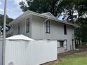 Exterior elevation featuring siding, mature trees, white fence, and meticulous landscaping at 4312 Idlewood Ln, Tucker, GA 30084