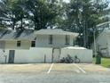 View of exterior featuring a two-story design with siding, white fence, parking spaces and mature trees at 4312 Idlewood Ln, Tucker, GA 30084