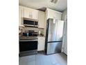 Kitchen with stainless steel appliances, white cabinets, and gray tile flooring at 4312 Idlewood Ln, Tucker, GA 30084
