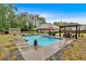 Inviting backyard pool with patio seating, pergola, and a shed for outdoor storage at 7030 Mandevilla Ln, Douglasville, GA 30135