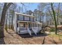 Attractive two-story home featuring a covered front porch and set amidst a serene, wooded landscape, offering privacy at 3271 Sutcliffe Nw Rdg, Marietta, GA 30064