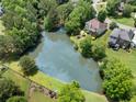 Aerial view of a home with a backyard pond, mature trees, and a well-maintained lawn at 514 Augusta Dr, Canton, GA 30115