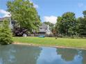 Spacious backyard with a tranquil pond, lush greenery, and a wooden fence at 514 Augusta Dr, Canton, GA 30115