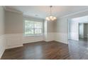 Elegant dining room features chair rail, new flooring, and modern lighting fixture at 7190 Cavender Sw Dr, Atlanta, GA 30331