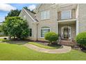 Close-up of brick home with manicured landscaping and entryway featuring brick accents and lion statues at 2700 Still Farms Ct, Lawrenceville, GA 30043